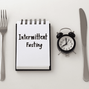 knife and fork with clock and notepad for keto diet intermittent fasting